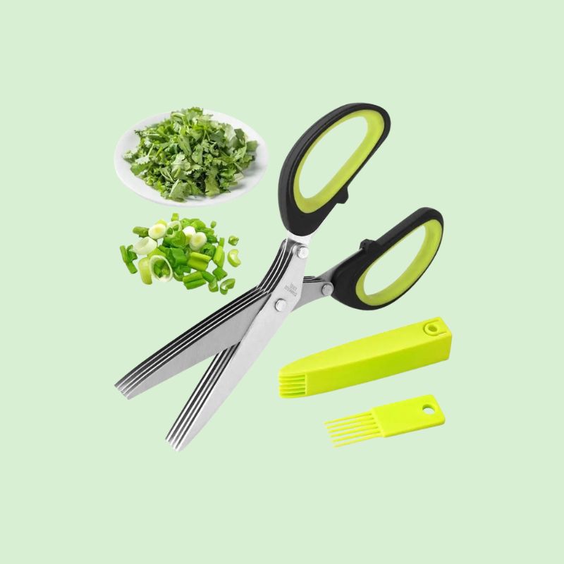 Ciseaux de cuisine 5 lames en inox posés à côté de ciboulette et de coriandre