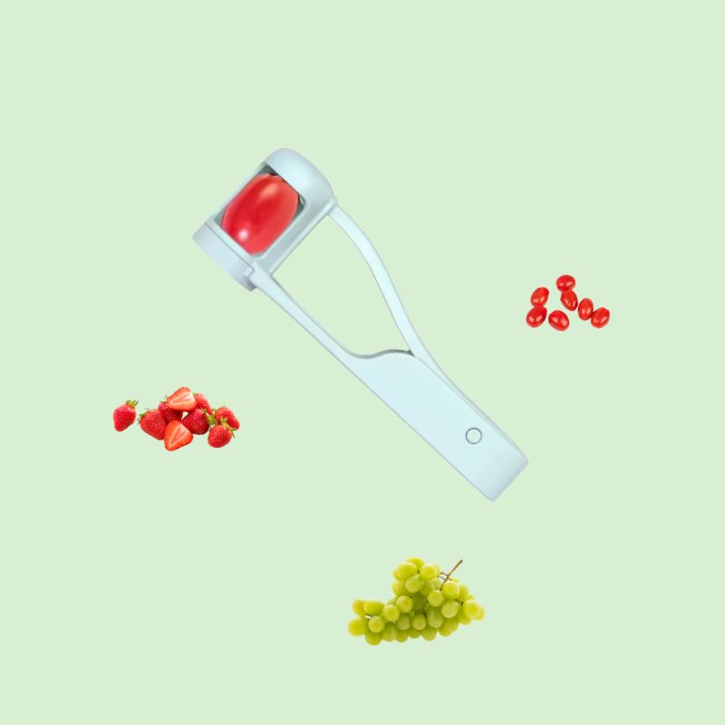 Coupe-raisin présenté avec des tomates et des raisins en quartiers pour illustrer son utilisation