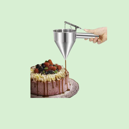 Distributeur de pâte en inox en train de verser du caramel sur un gateau