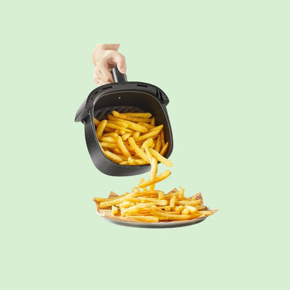 Friteuse à air 2 litres avec des frites à l’intérieur et service des frites dans une assiette