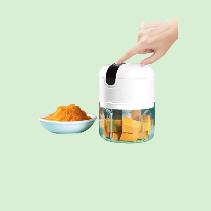 Hachoir électrique multifonction en train de mixer des légumes après appui sur le bouton de démarrage.