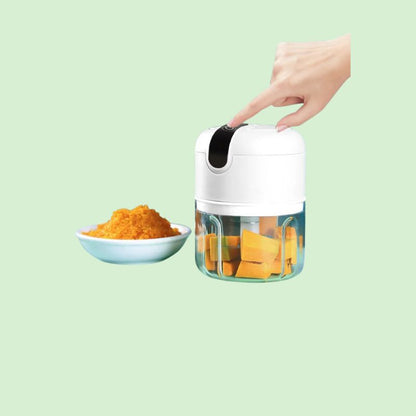 Hachoir électrique multifonction en train de mixer des légumes après appui sur le bouton de démarrage.