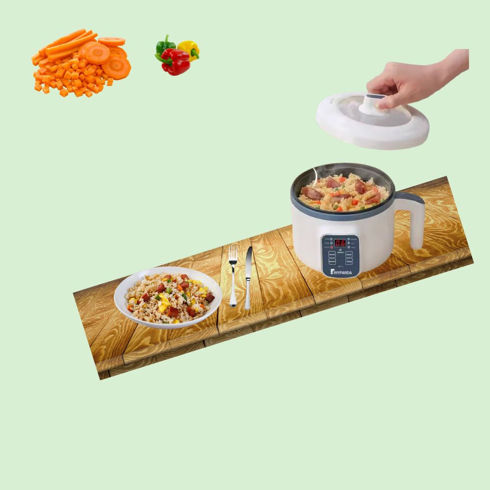 Mini cuiseur à riz électrique sur plan de travail cuisant du riz avec légumes, accompagné d’une assiette prête .