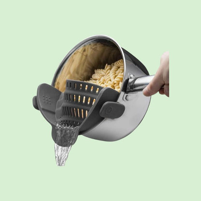 Passoire silicone clip en train d'égoutter des pâtes .