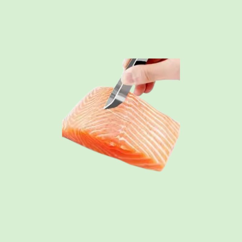 Personne utilisant une pince à arêtes en acier inox pour retirer les arêtes d’un poisson