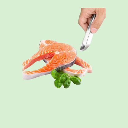 Pince à arêtes en acier inox posée à côté d’un poisson frais