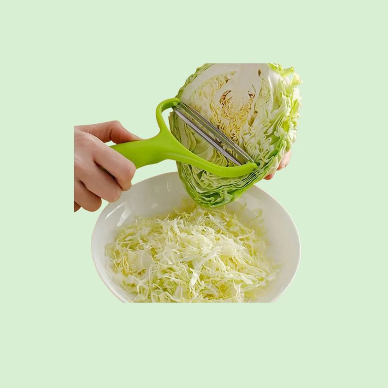 Râpe à légumes en acier inoxydable, montrant le produit prêt à râper du chou pour une utilisation facile et efficace en cuisine.